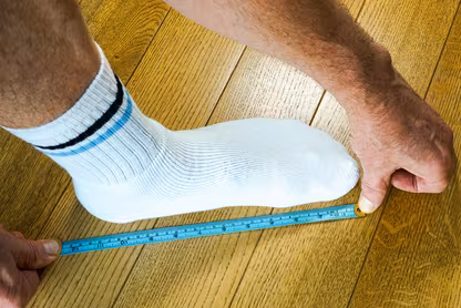 Man measuring his foot with a tape measurer