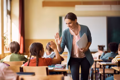 Teacher high fiving a student in their classroom